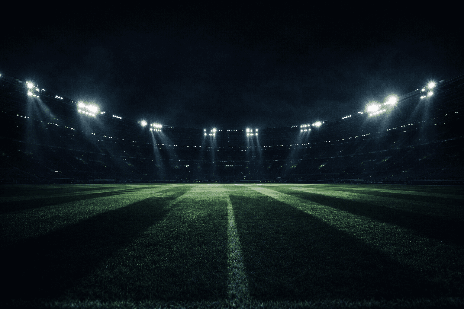 Empty Champions League stadium at night seen from the pitch level